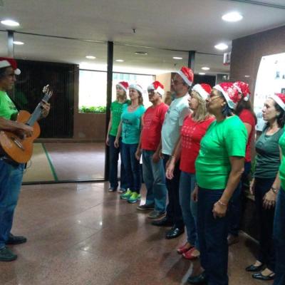 Coralistas cantando usando gorros natalinos