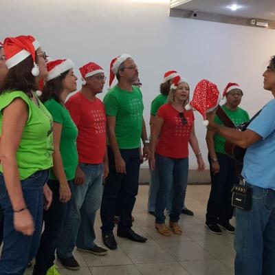 Coral reunido usando gorro natalino