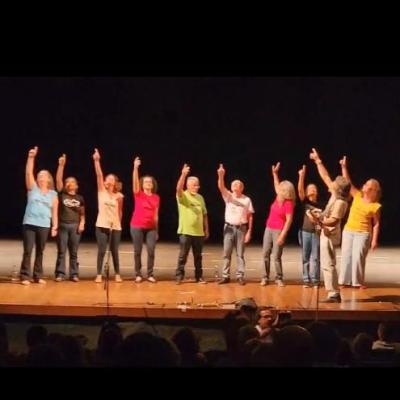 Coral se apresentando. Todos apontando pra cima.